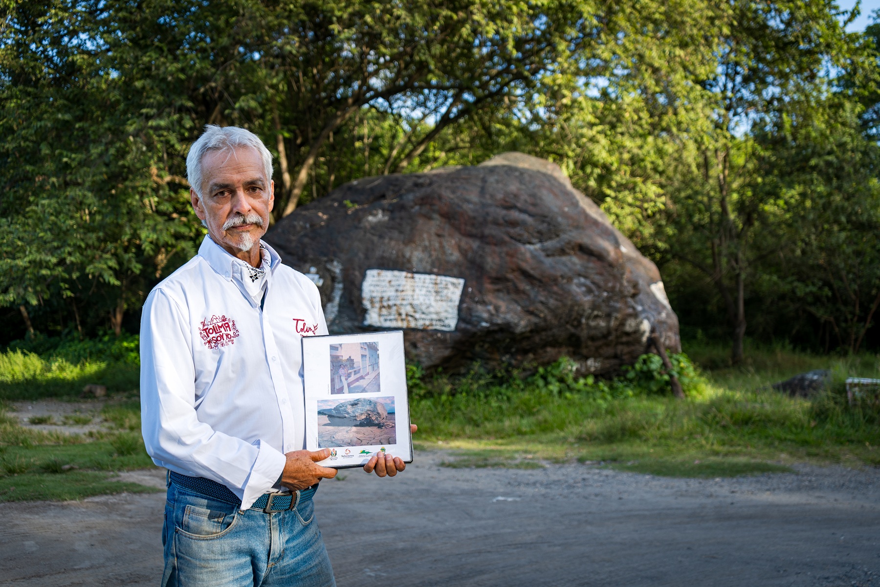 José Darío Nova sosteniendo un álbum fotográfico con imágenes antiguas de Armero, Tolima.