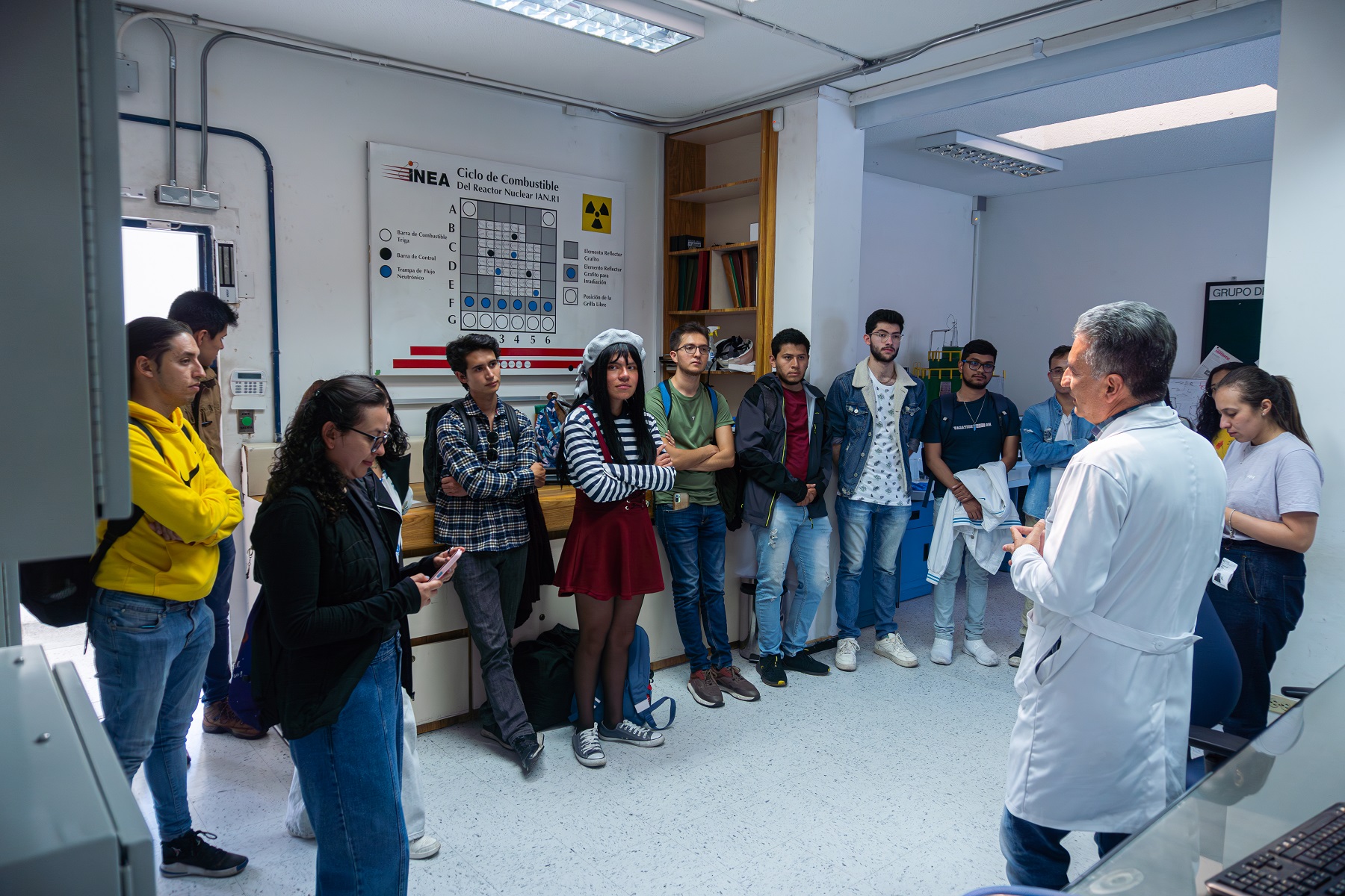Estudiantes universitarios en la sala de monitoreo durante recorrido por el reactor nuclear.